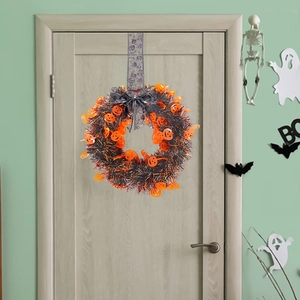 Ghirlanda di Halloween con zucche arancioni e tinsel nero su una porta di legno rustica