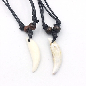 Detail of curved faux wolf tooth pendants with marbled texture on black cord necklaces