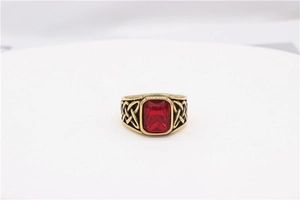 Detail of vintage gold ring with large red rectangular gemstone and Celtic knot carvings