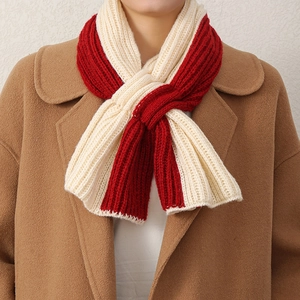 Détail d'une écharpe croisée en tricot épais rouge et blanc avec une texture douce