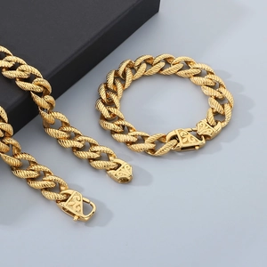 Close-up of golden twisted curb chain jewelry set featuring intricately carved clasp details