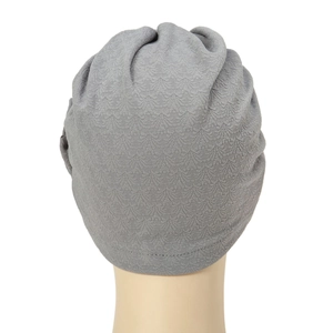 Detail view of the elegant grey floral headscarf with refined pleated fabric textures
