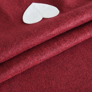 Red wool felt Christmas tree skirt featuring a white heart detail for festive tree decor