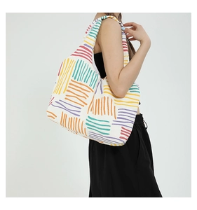 Close-up of a large canvas tote bag featuring vibrant colorful stripes and textured fabric