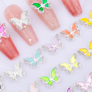 Detail of colorful macaron butterfly nail charms with rhinestones and enamel wings
