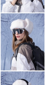Close-up of white faux fur trapper hat with outdoor skiing jacket and goggles
