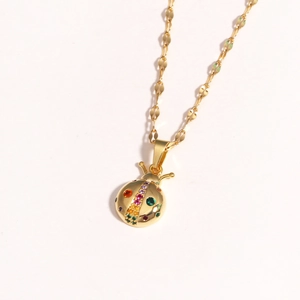 Golden ladybug necklace with multicolored crystals on a clean white background