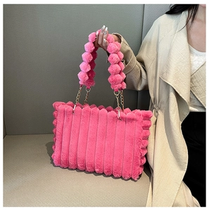 Detailed shot of pink plush tote bag featuring ribbed texture and fuzzy ball chain strap