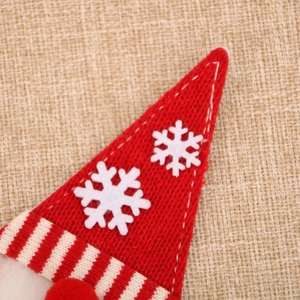 Primo piano del cappello di Natale in maglia rossa con fiocchi su tela di iuta