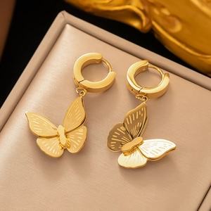 Elegant gold butterfly hoop earrings with brushed metal texture on a jewelry display