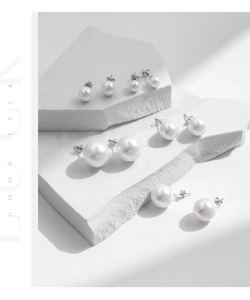 Macro detail of various sized S925 sterling silver pearl stud earrings set on stone