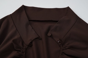 Détail du haut côtelé marron chocolat avec un col polo et des boutons recouverts de tissu