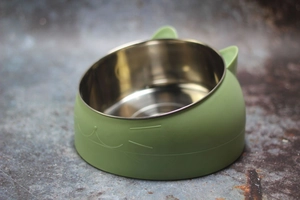 Detail view of the green cat-ear shaped bowl with stainless steel liner and whiskers relief