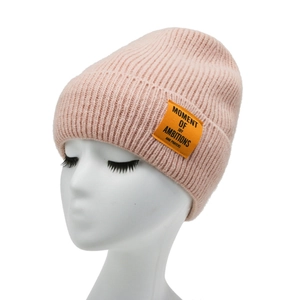 Pink knitted beanie hat with orange label patch for winter warmth and casual style