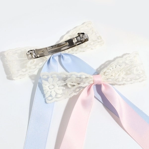 Detailed view of lace ribbon bow hair clips with silver metal spring clips and floral lace