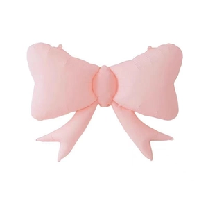 Detail of large matte pink bow foil balloon for party decoration on white background