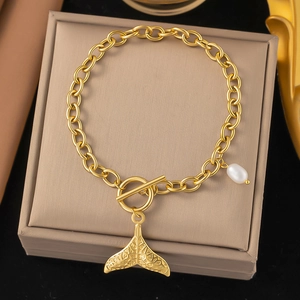 Detail of 18K gold-plated chain bracelet with whale tail pendant and white pearl charm