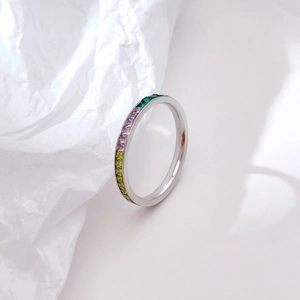 Minimalist silver ring with rainbow channel-set square gemstones on white textured background