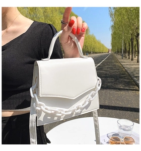 Detail of white leather small crossbody bag with chunky acrylic chain decoration