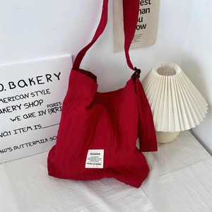Detailed view of red vertical stripe canvas bag with SOZAKKA label and adjustable strap