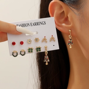 Detail view showing a set of 7 Christmas themed earrings and model wearing tree studs
