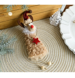 Detail of plush Christmas reindeer ornament with red hat and star on wooden background