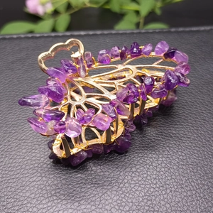 Detailed close-up of golden alloy leaf hair claw with hand-wrapped purple amethyst stones