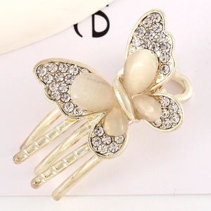 Macro shot of gold butterfly hair clip featuring inlaid rhinestones and opal stones