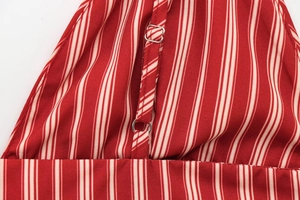 Detail of red and white striped fabric with silver metal adjustment buckle on the strap