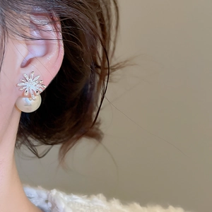 Detail view of fireworks-inspired silver earrings with zircon and rear pearl backing
