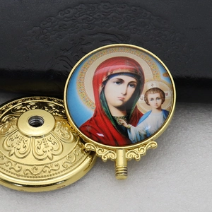 Detail of two-piece gold metal religious ornament featuring colorful icon with screw thread