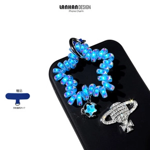 Close-up of aurora blue spiral phone charm with star pendant and planet rhinestone