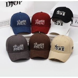 Detail of distressed baseball caps with TEXS 1983 embroidery and ripped brim effects