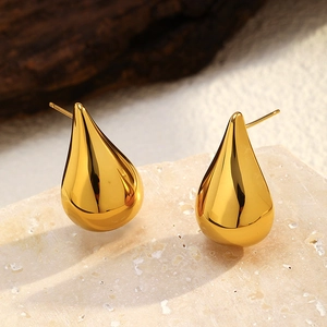 Detailed close-up of golden teardrop stud earrings with a polished 18K gold-plated finish