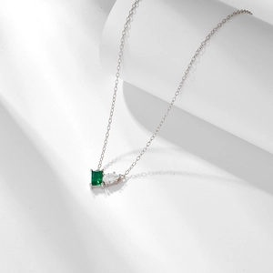 Detail of s925 silver necklace with rectangular emerald and teardrop zircon pendant