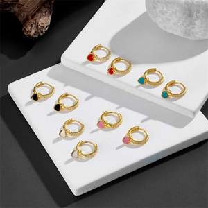 Golden heart drop hoop earrings with colorful enamel and crystal accents on stone props