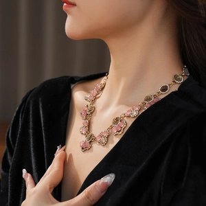 Detail of vintage floral necklace with pink gemstones and crystals on model