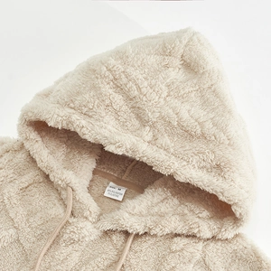 Detail of soft beige sherpa hoodie lining showing plush texture and fabric composition label