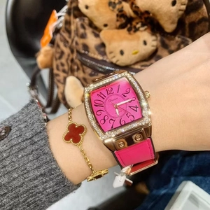 Close-up of pink square dial watch with diamond-set case and leather strap on wrist