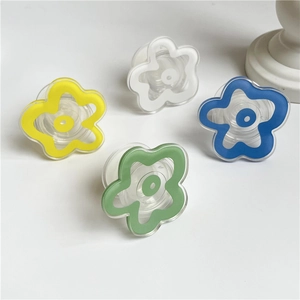 Flat lay showing yellow, white, blue, and green flower shaped phone grip stands