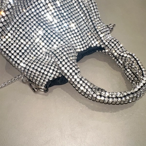 Close-up of sparkling silver rhinestone handbag with elegant metal chain and dark inner lining