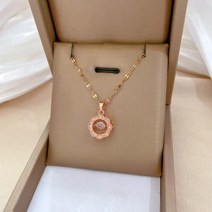 Elegant rose gold necklace with a pink gemstone ring pendant in a brown jewelry box