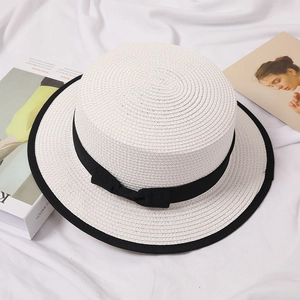 Elegant white flat top straw boater hat with black ribbon bow and trim for summer travel