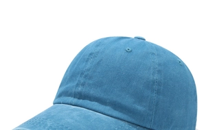 Detail of washed cotton texture and reinforced stitching on a vintage blue baseball cap