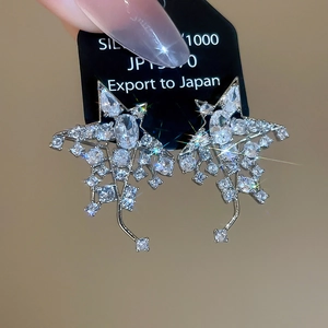 Détail de boucles d'oreilles étoiles en argent avec zircons sur une carte noire