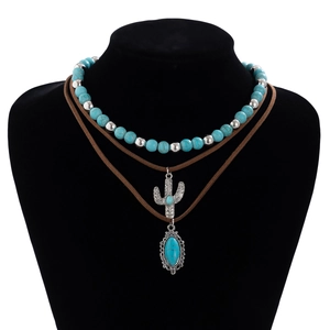 Detail of bohemian necklace with turquoise beads, cactus pendant, and vintage carvings
