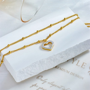 Double-layer gold heart anklet with sparkling rhinestones and metal beads on white stone