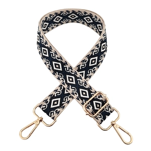 Detailed view of bohemian diamond pattern woven bag strap with golden metal buckles