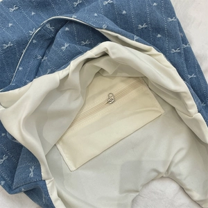 Détail de l'intérieur du sac en jean avec poche zippée sécurisée et doublure en beige