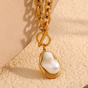 Macro detail of 18K gold plated chain with baroque pearl pendant and stylish OT clasp